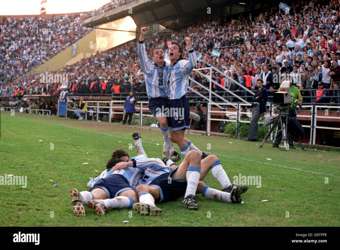 Argentina's Maximiliano Rodriguez (on floor, c) is mobbed after scoring the third goal, as teammates Mauro Rosales (top l) and Julio Arca (top r) celebrate their imminent victory Stock Photo