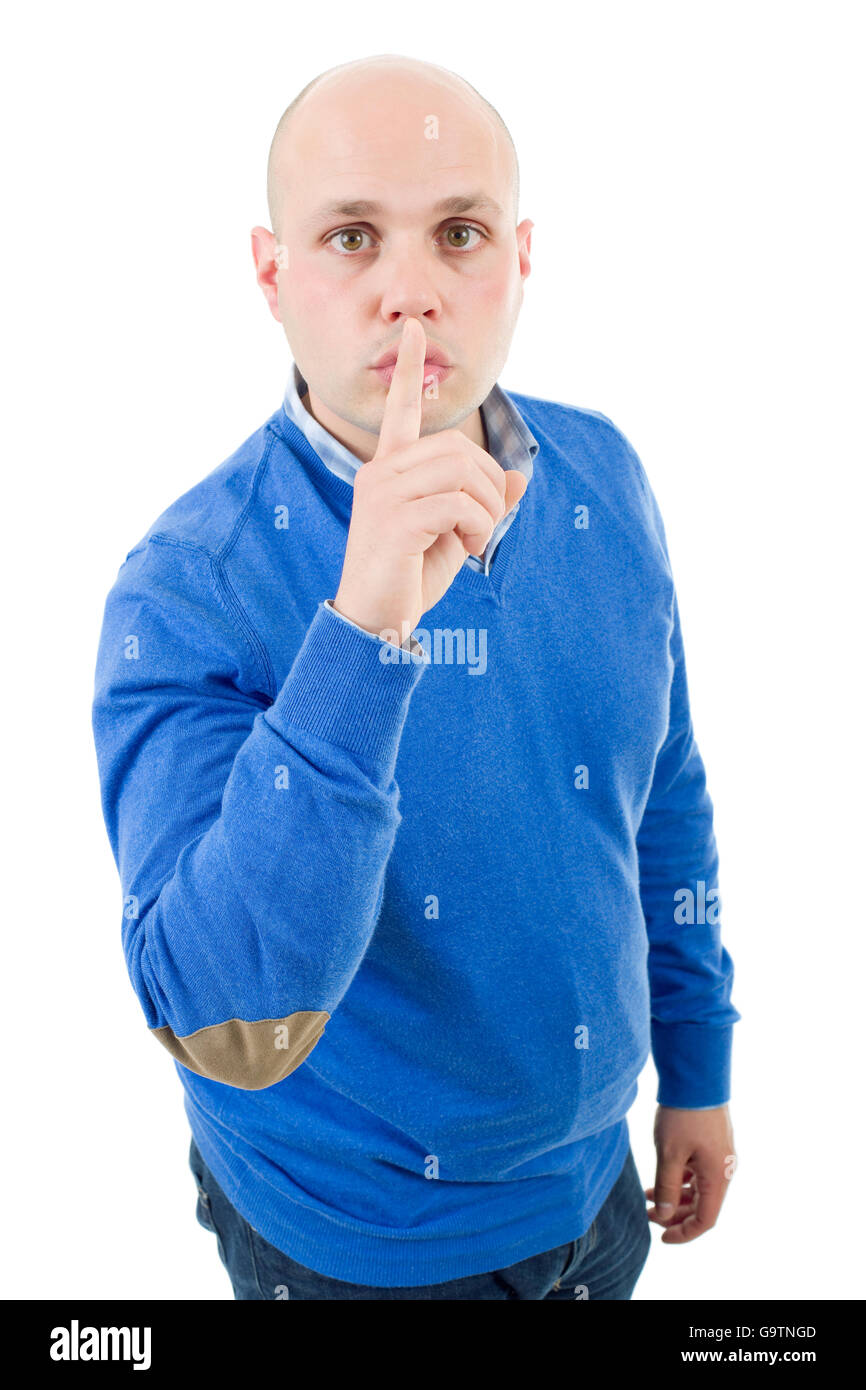 portrait of a young bald man making a shushing gesture with his finger, isolated on a white studio background. Stock Photo