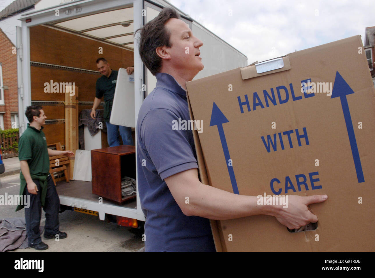 Conservative Party leader David Cameron helps carry his belongings into his new house in west London. Stock Photo