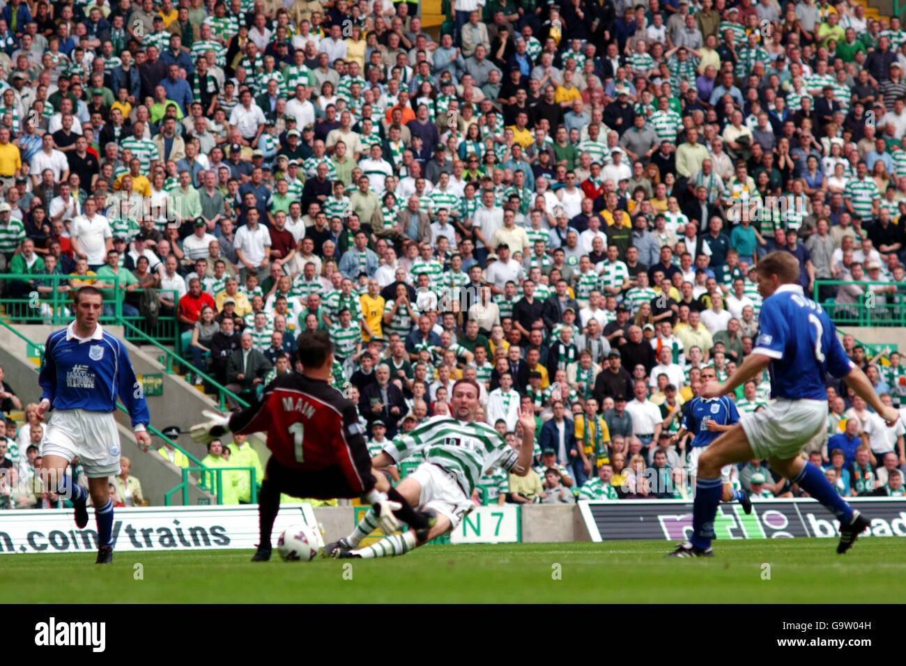 Celtic's Paul Lambert slides the ball past St Johnstone goalkeeper Alan Main to score their second goal Stock Photo