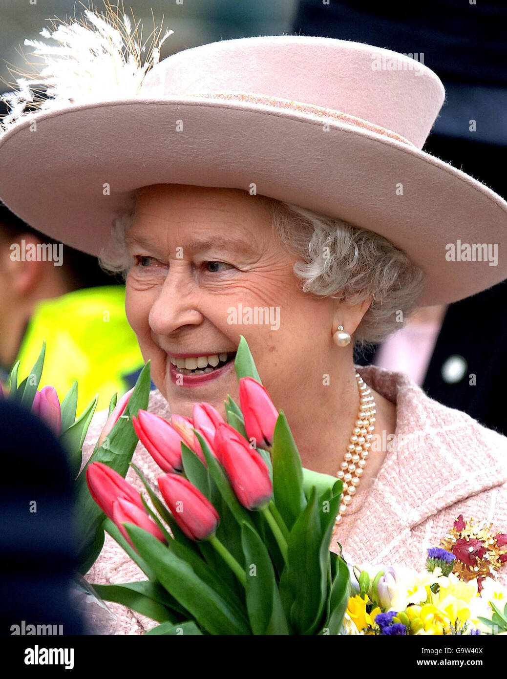 Britain's Queen Elizabeth II holds flowers during a walkabout outside Manchester Cathedral today following the traditional Royal Maundy Service. Stock Photo