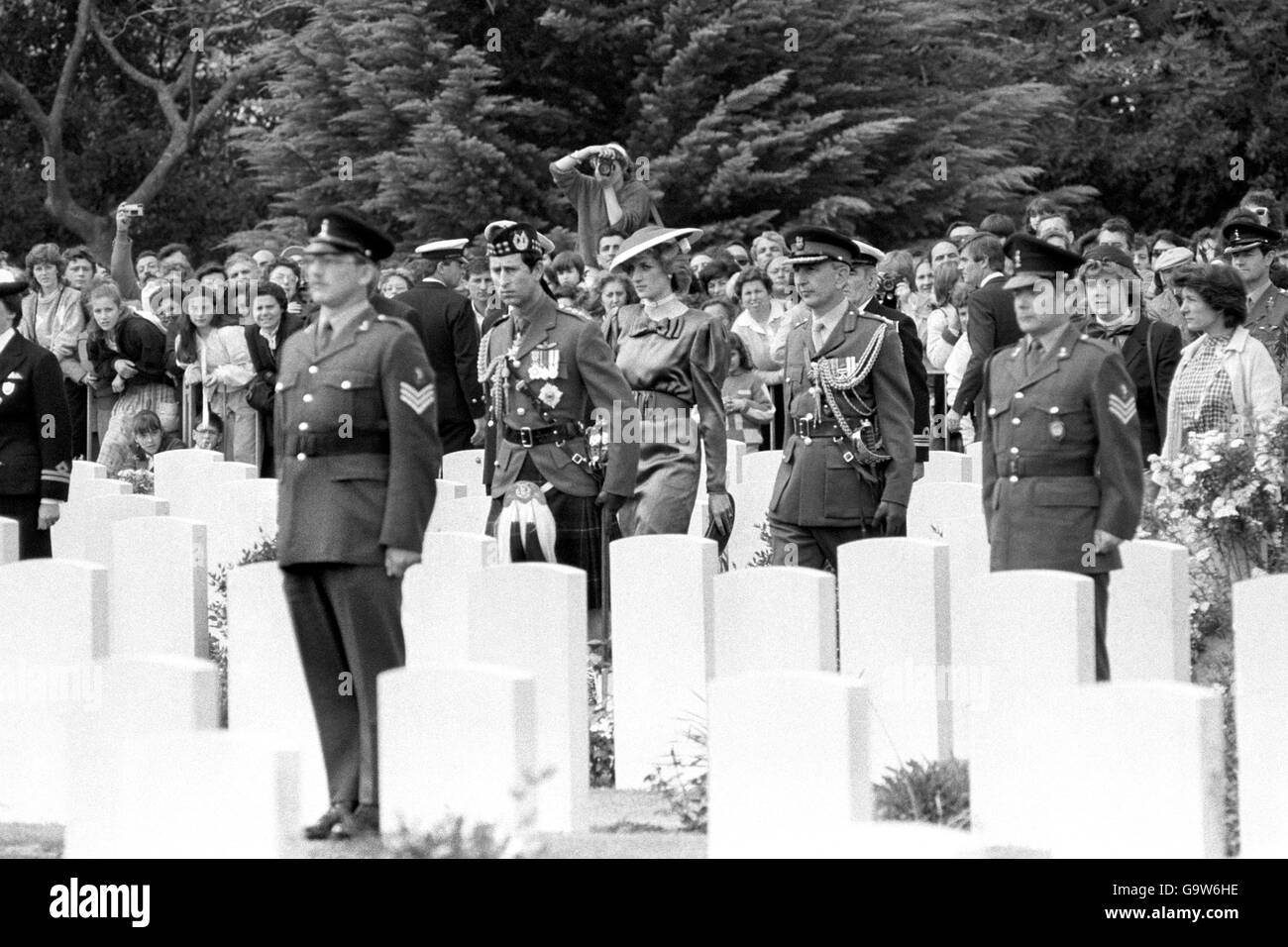 The Prince and Princess of Wales walking through grave stones before a ceremony at the Anzio Beach Head cemetery. The Princess wears a wine coloured silk dress and the Prince the uniform of the Gordon Highlanders. Stock Photo