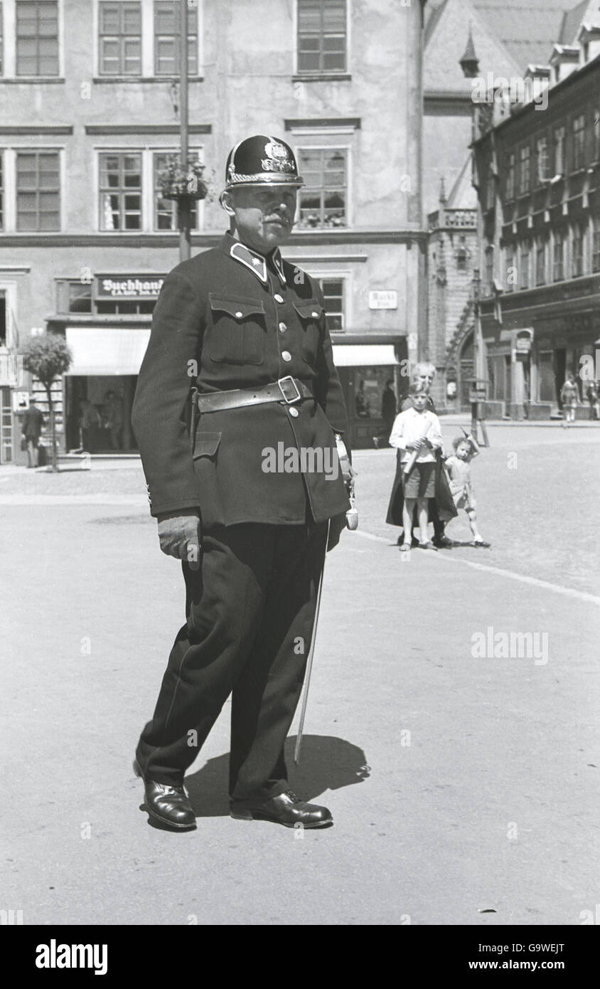 1930, historical, Czech policeman in town square in Cheb (Eger) in the Sudetenland, in pre-ww11 Czechoslovakia, with traditional helmet and tunic. Stock Photo