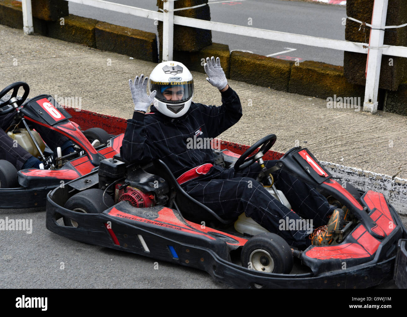 Amateur displaying buzzing happiness in prominent driving position ready to begin track racing in his Go Cart at Karting Leicester in Great Stratton. Stock Photo