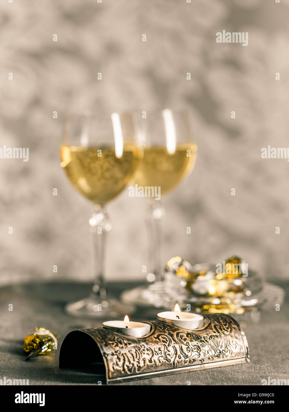 crystal glasses with wine, chocolates and candles Stock Photo