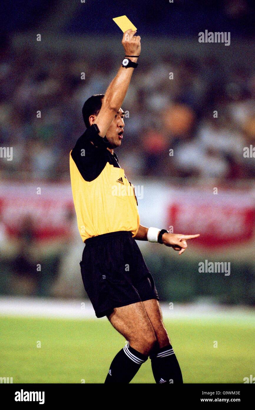 Referee Masayoshi Okada identifies the recipient of the yellow card as he flourishes it Stock Photo