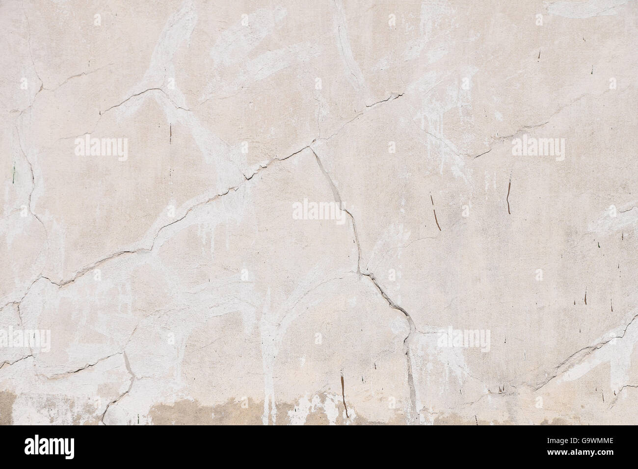 Background texture of old beige pink painted plaster wall with cracks and grunge repair stains Stock Photo