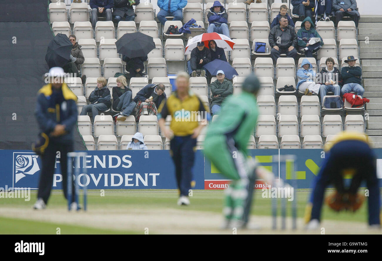 Spectators shelter from the drizzle and rain during Hampshire's match against Ireland in the Friends Provident Trophy at the Rose Bowl in Southampton. Stock Photo