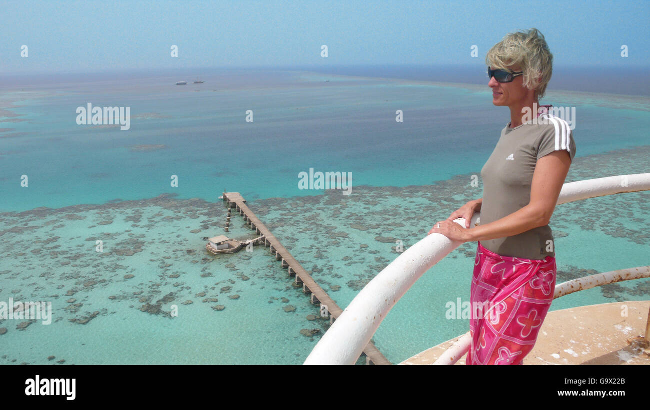 woman looking at red sea reef with jetty from Sanganeb lighthouse, Sudan, Africa Stock Photo