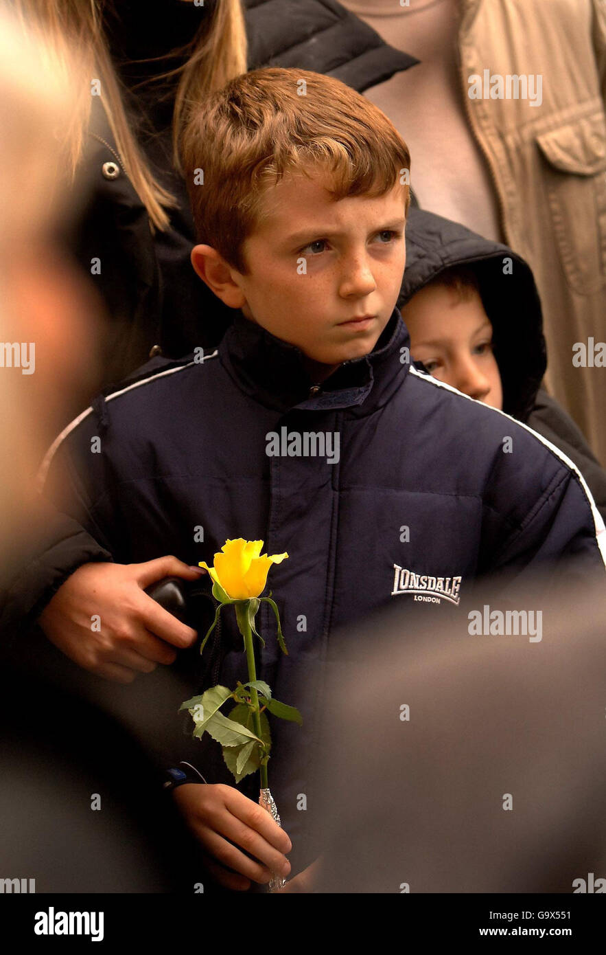 A young boy holds a flower and prays during a two minute silence in memory of those who died in the Potters Bar rail crash. Stock Photo