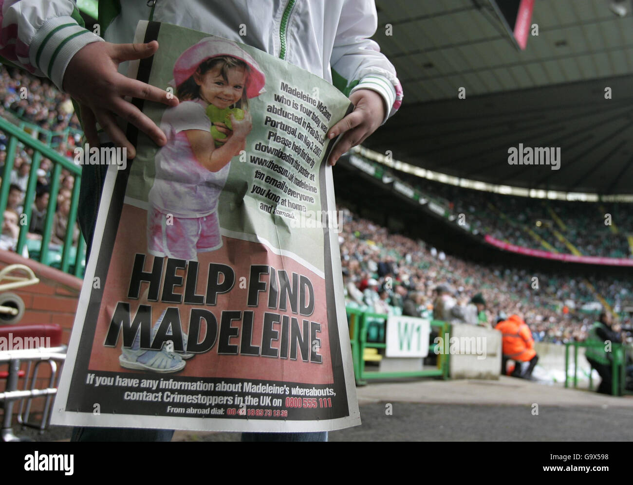 A young person holds a poster for missing girl Madeleine McCann during the Bamk of Scotland Premier League match against Aberdeen at Parkhead, Glasgow. Stock Photo