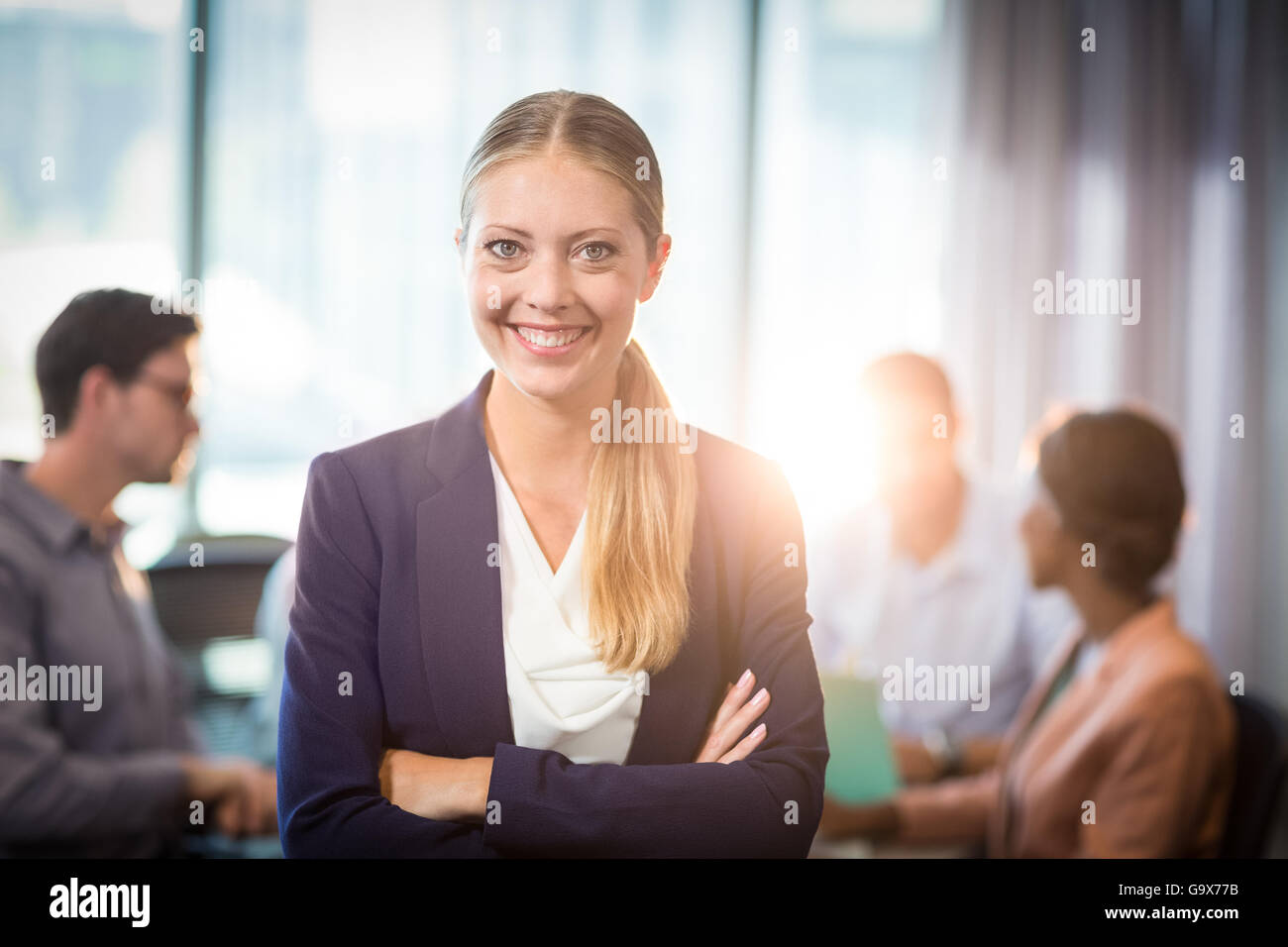 Businesswoman standing with arms crossed in the office Stock Photo - Alamy
