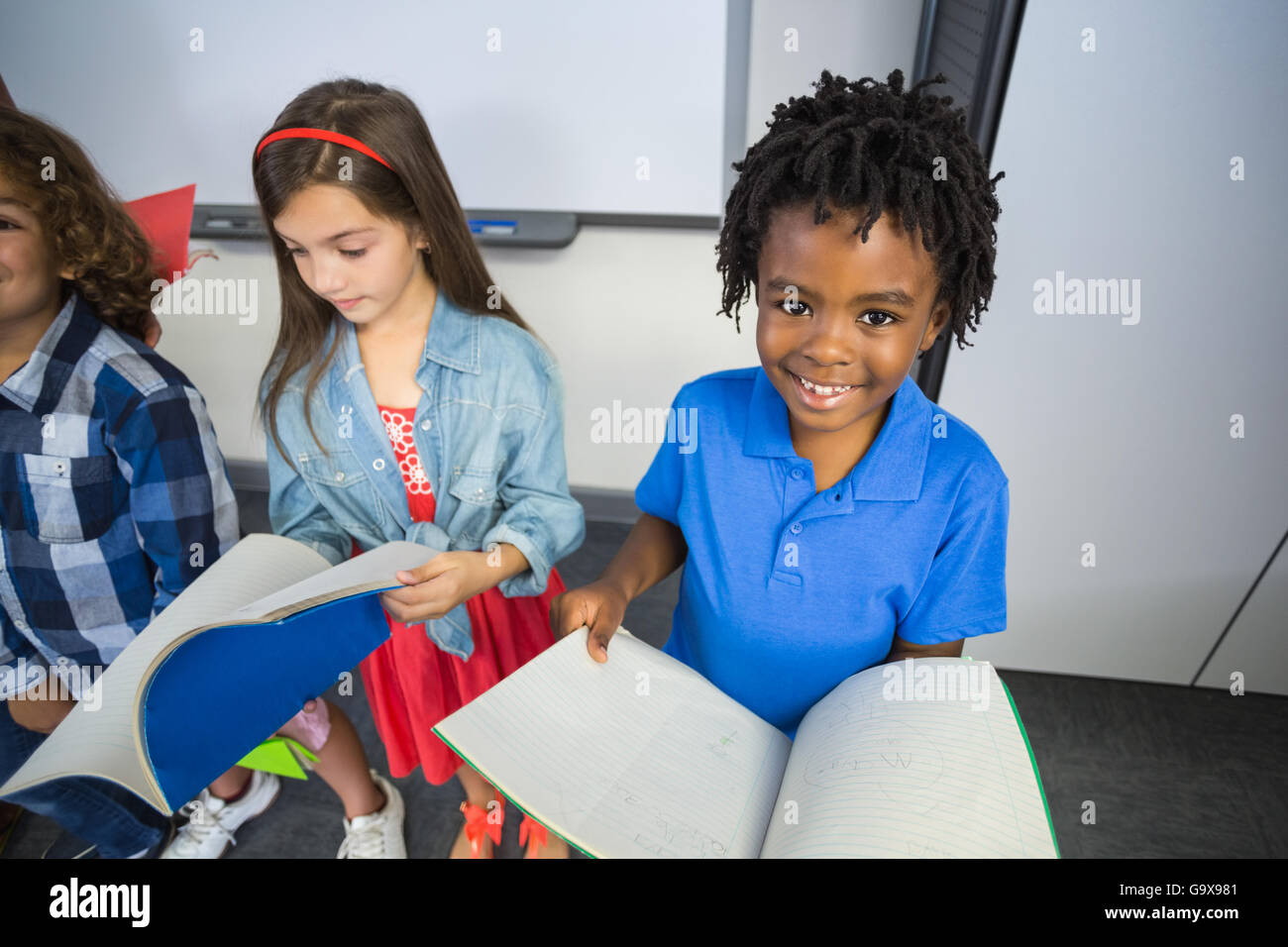 Kids reading book in classroom Stock Photo - Alamy
