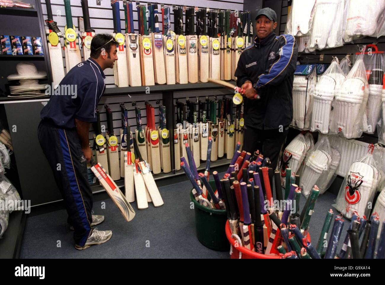 (L-R) Surrey's Nadeem Shahid and Alex Tudor try out the bats in the Centre shop Stock Photo
