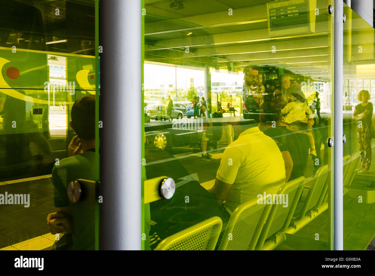 Stuttgart, Germany - June 25, 2016: People waiting for a bus as seen through modern yellow glass in the new Stuttgart Central Bu Stock Photo