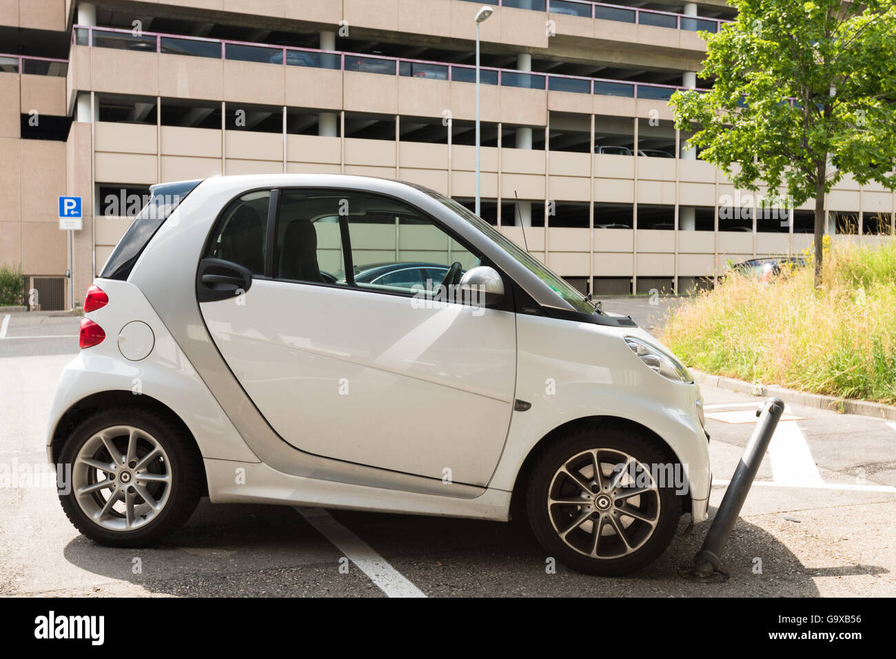 Stuttgart, Germany - June 25, 2016: Very bad parked small Smart car, hitting a metal blocker while parking illegally in a blocke Stock Photo