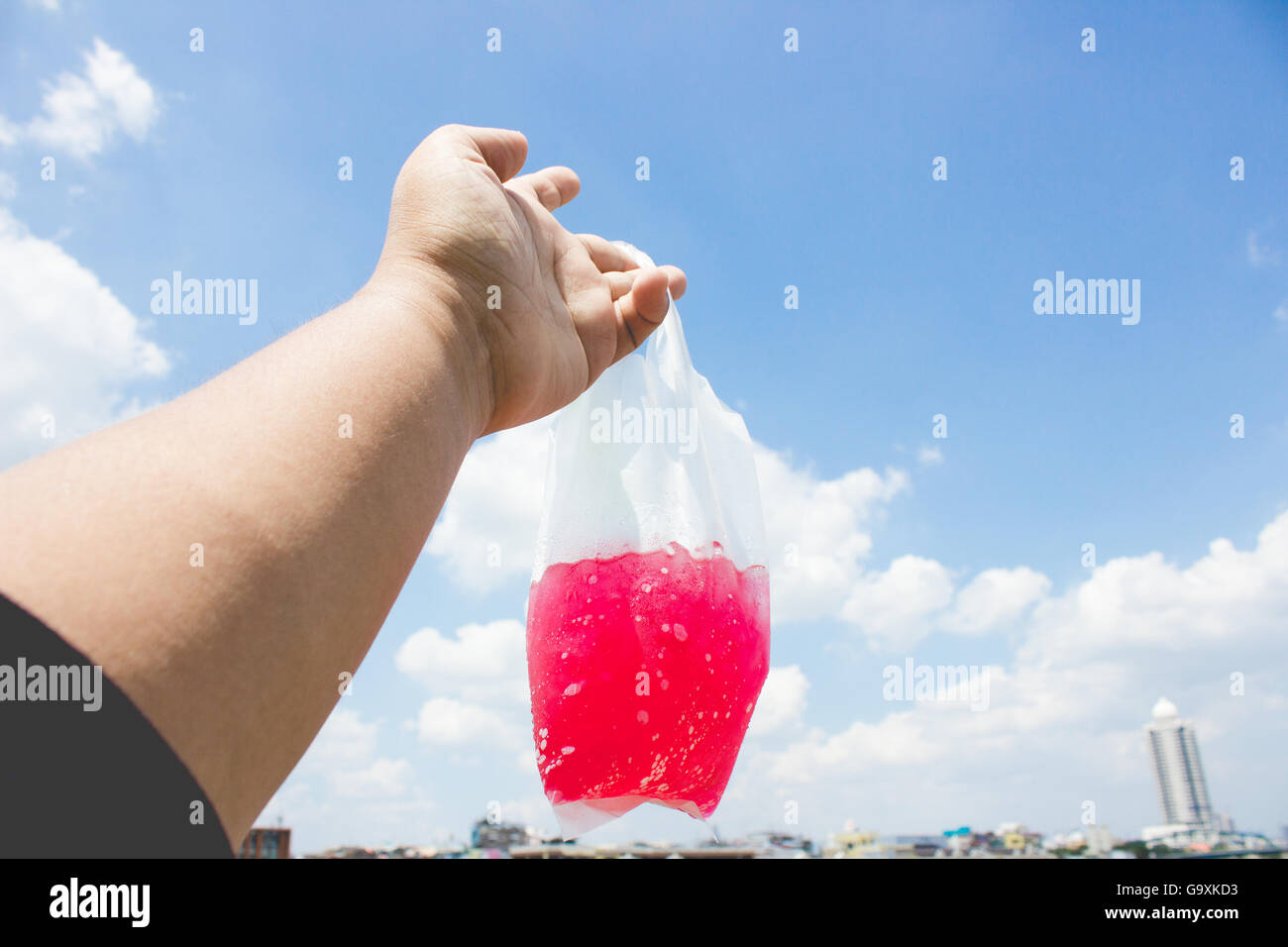 Red sweet soda in plastic bag and blue sky background Stock Photo - Alamy