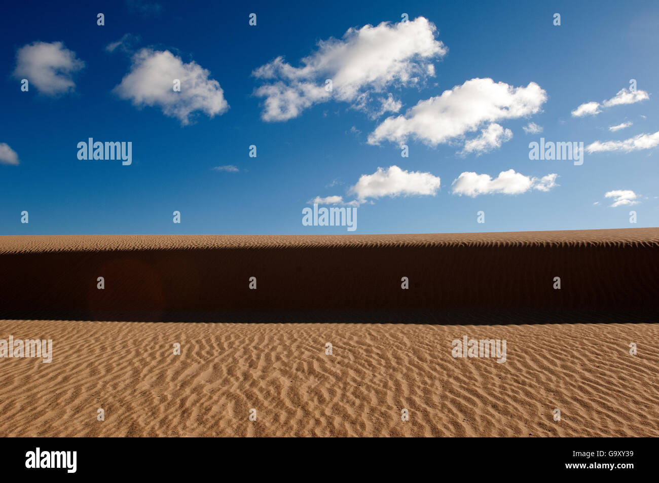 Sand Dunes with beautiful white clouds in a blue sky Stock Photo - Alamy