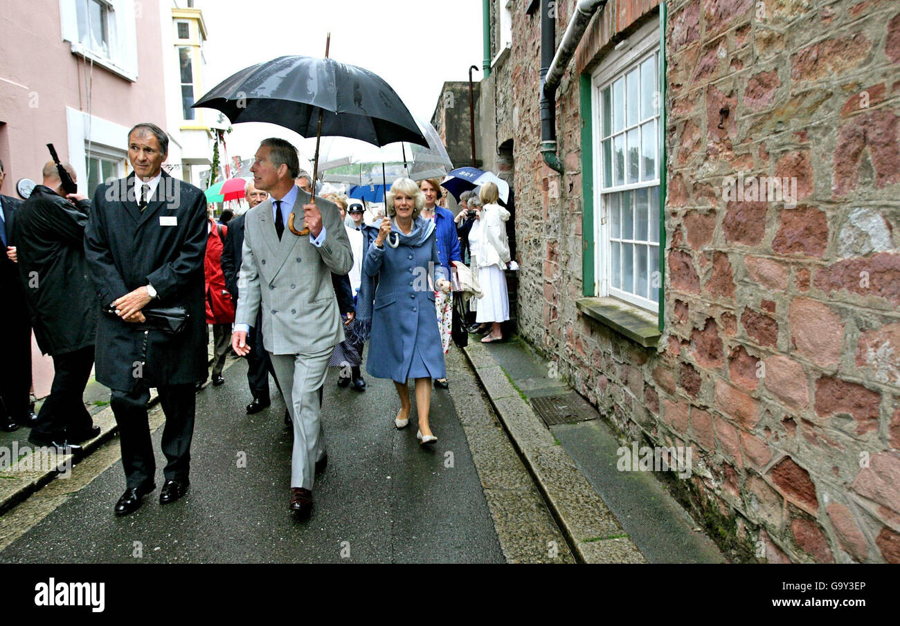 Chairman of the local Parish Council Tony Carne (left), shows the Prince of Wales and Duchess of Cornwall around on a tour of the villages of Kingsand and Cawsand in Cornwall. Stock Photo