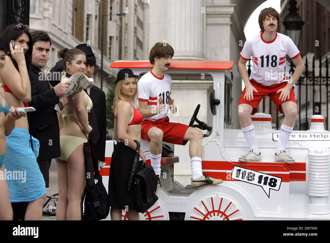 Models pose as businessmen and women in shorts and bikinis during the launch of the 118 118 'Alfresco Urban Tube' - an outdoor alternative to the normal underground train provided over the summer months by the directory company in order to promote the new trains schedule service - at Marble Arch in central London. Stock Photo