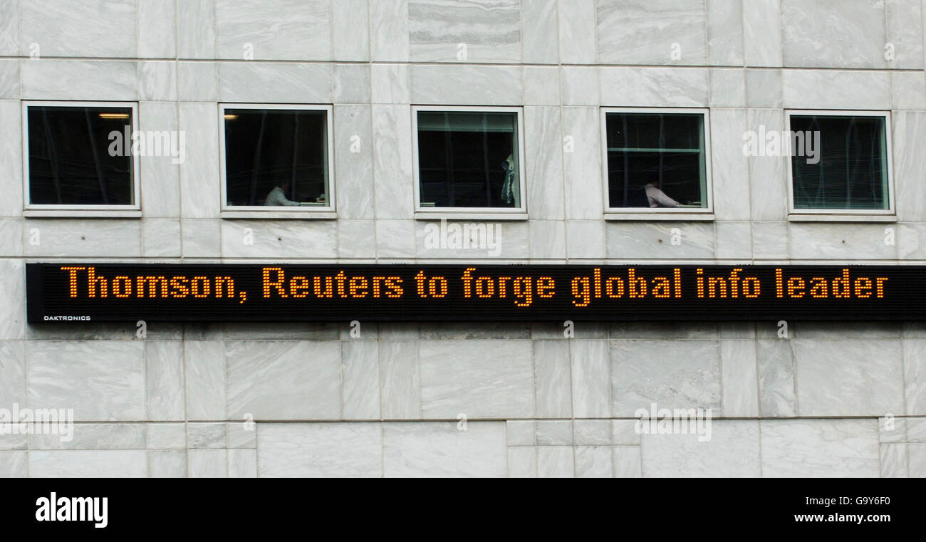 The news that Canadian media giant Thomson have bought rival agency Reuters is flashed across a screen at 'Reuters Plaza' in Canary Wharf, London. Stock Photo