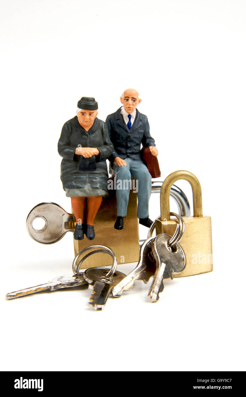 Miniature figurines of elderly couple sitting on padlocks Stock Photo