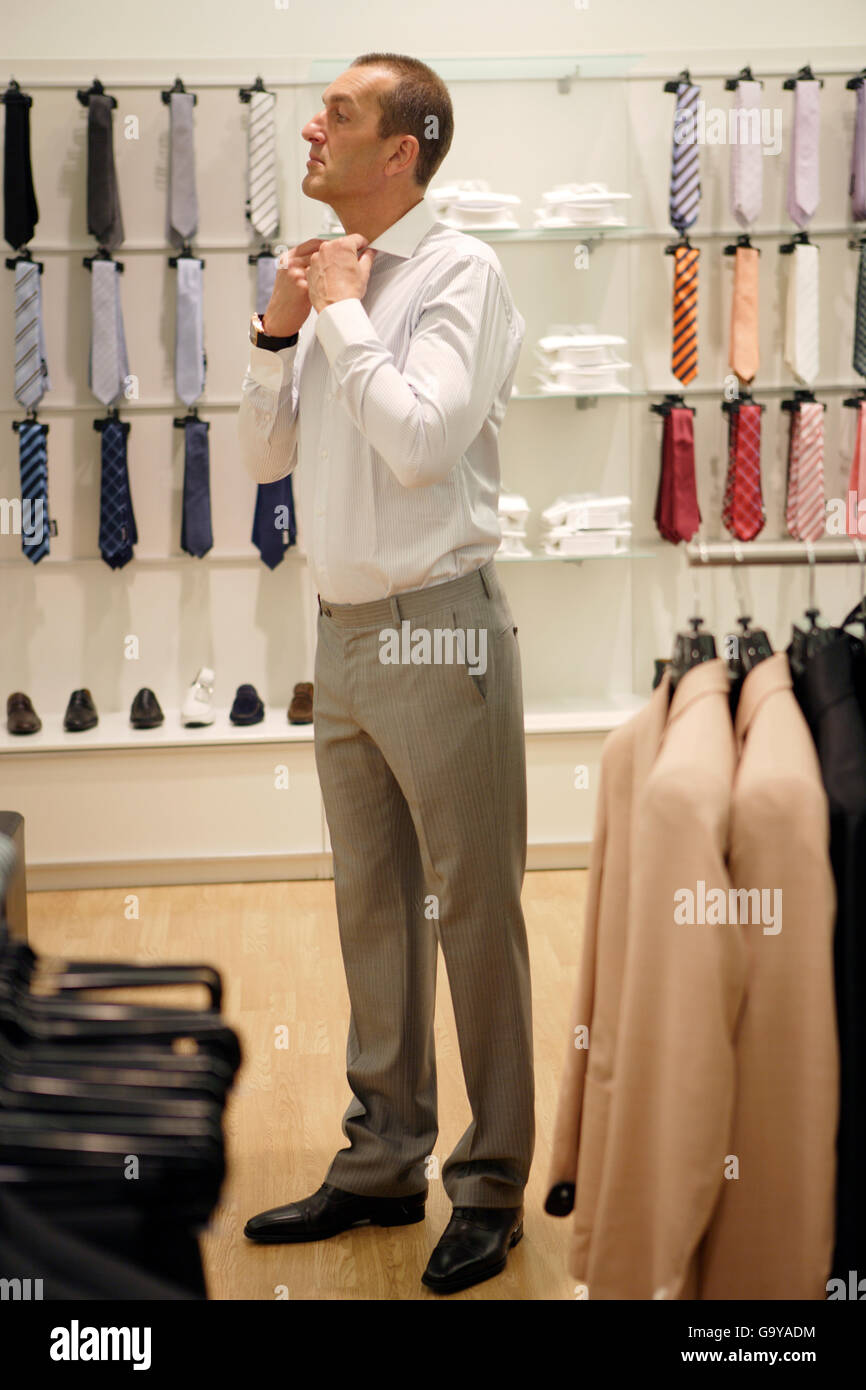 A man selecting clothes in a men's outfitter Stock Photo Alamy