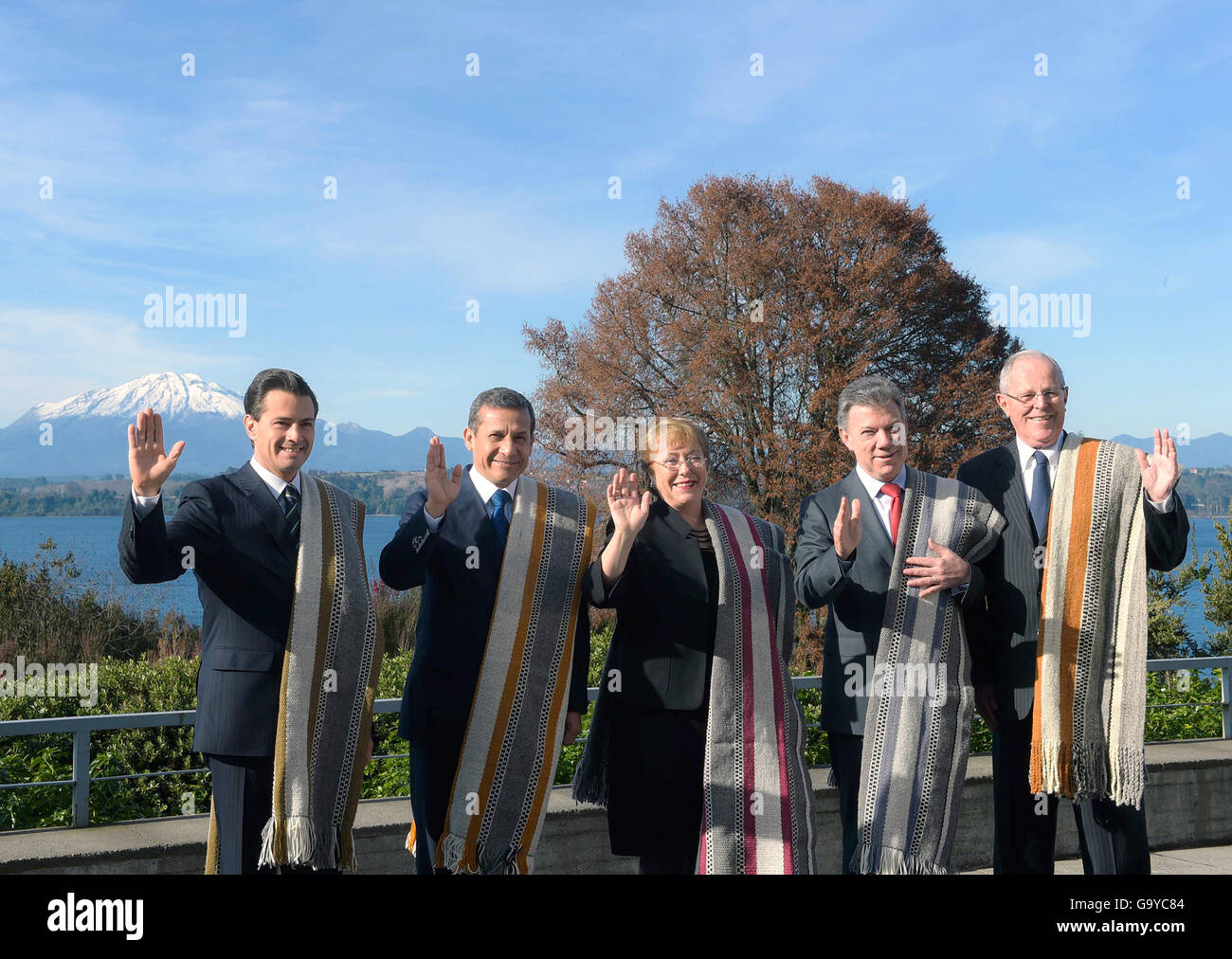 The leaders of the Pacific Alliance wave during a group photo during the 11th Presidential Summit of the Pacific Alliance July 1, 2016 in Puerto Varas, Chile. Leaders include L-R: Mexican President Enrique Pena Nieto, Peru President Ollanta Humala, Chilean President Michelle Bachelet, Colombian President Juan Manuel Santos and Peruvian president-elect Pedro Pablo Kuczynski. Stock Photo
