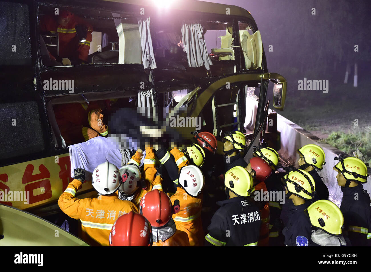 Tianjin. 2nd July, 2016. Rescue workers clean up the accident bus in Baodi section of north China's Tianjin, on July 2, 2016. A bus carrying 30 people rushed out of an expressway Friday night in north China's Tianjin City, and only four people were found alive as of 2 a.m. Saturday, according to rescuers. Credit:  Yue yuewei/Xinhua/Alamy Live News Stock Photo