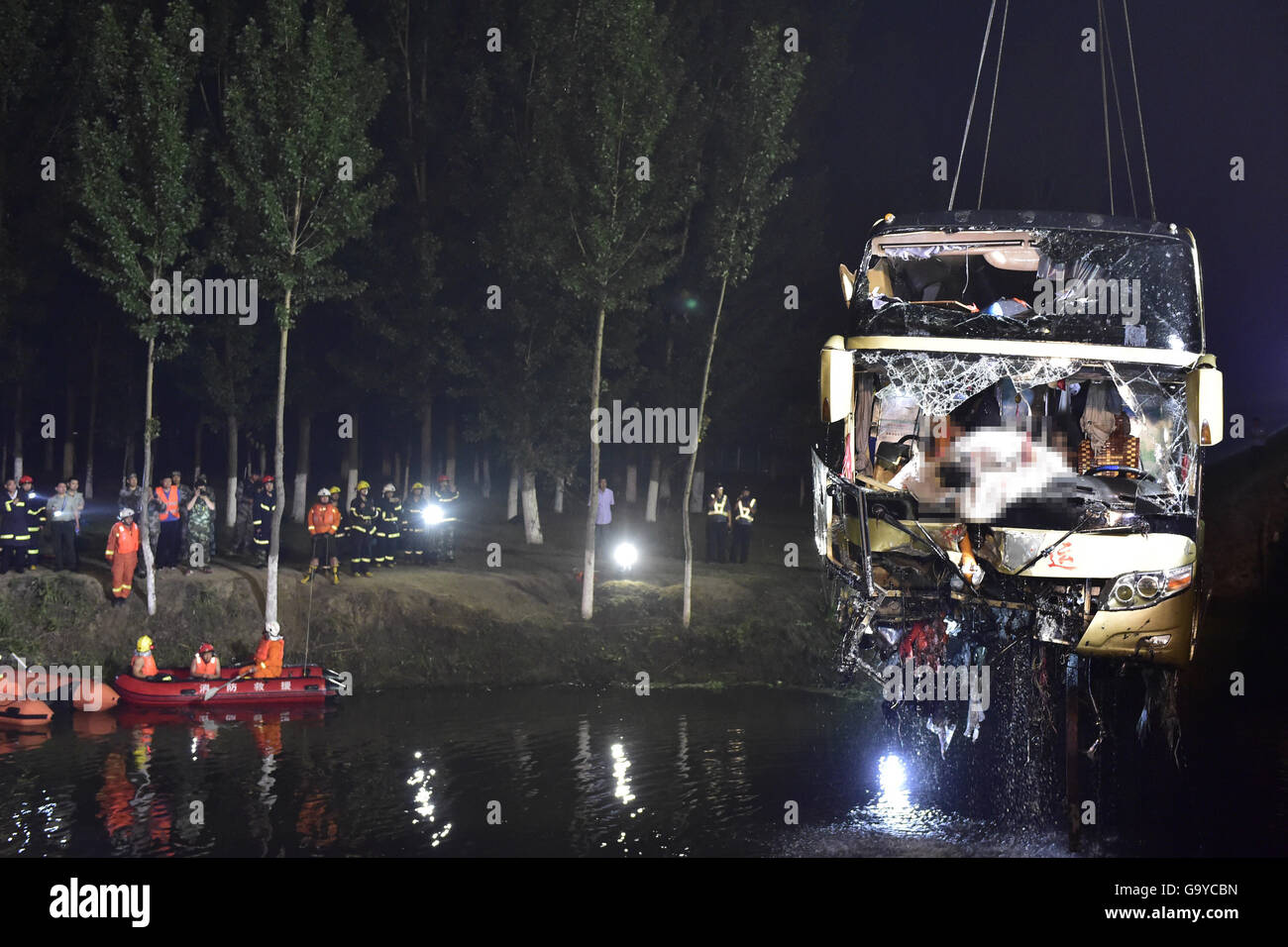 Tianjin. 2nd July, 2016. Rescue workers salvage the accident bus in Baodi section of north China's Tianjin, on July 2, 2016. A bus carrying 30 people rushed out of an expressway Friday night in north China's Tianjin City, and only four people were found alive as of 2 a.m. Saturday, according to rescuers. Credit:  Yue yuewei/Xinhua/Alamy Live News Stock Photo