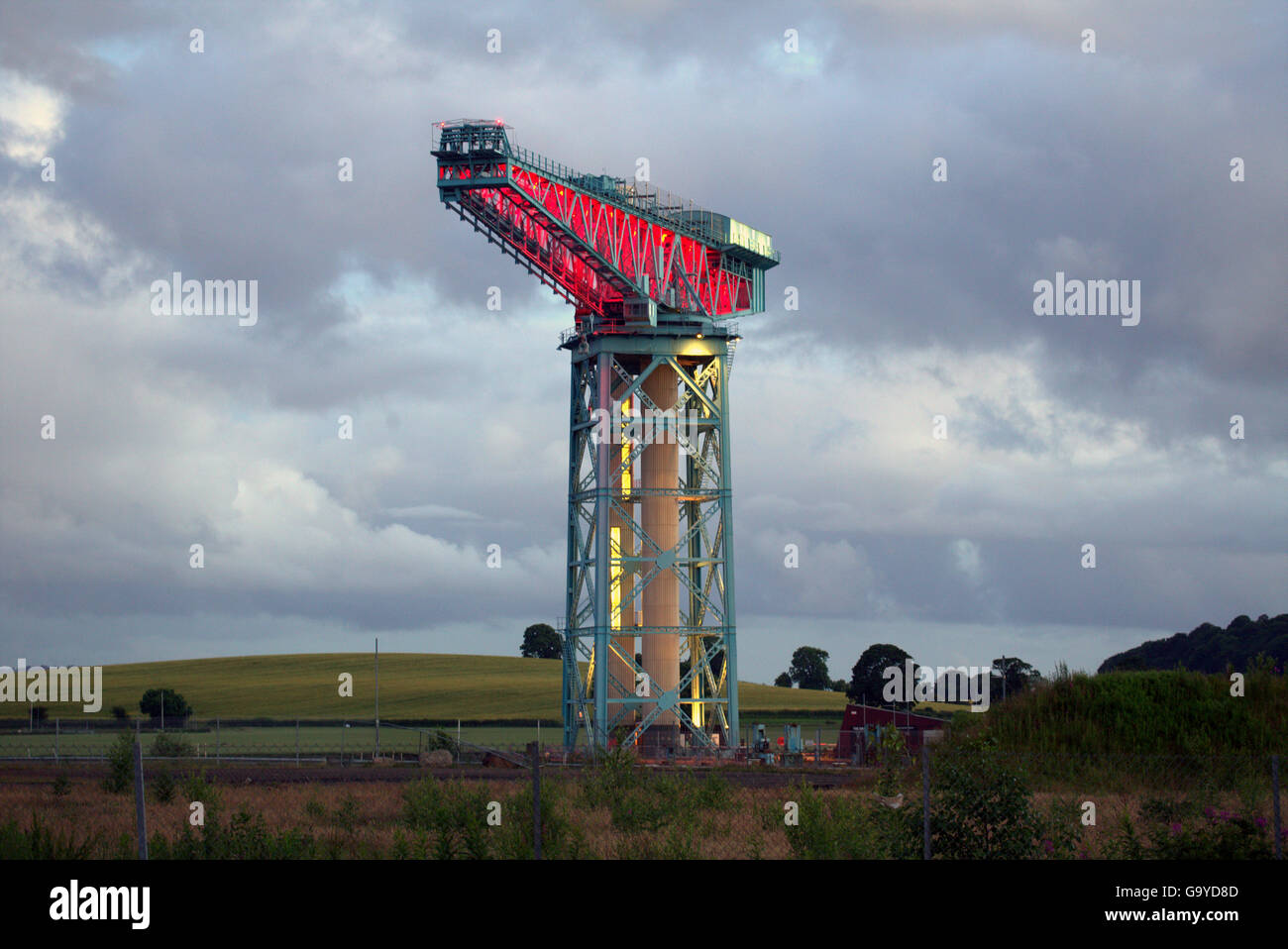 Clydebank, Glasgow, Scotland, UK 1st July 2016. Clydebank’s Titan crane the last remnant of John Brown’s Shipyard, that built both the Dreadnought warships and the Queen Elizabeth and Mary ship liners, was lit up poppy red at dusk to commemorate the end of the first day of the battle of the Somme. Credit:  Gerard Ferry/Alamy Live News Stock Photo