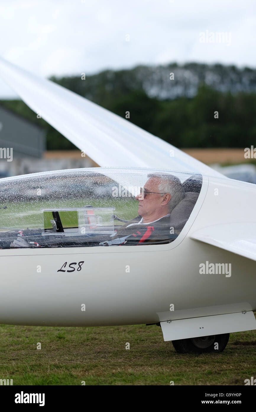 Shobdon airfield, Herefordshire, UK - July 2016 Competitors and pilots struggle with heavy showers and rain clouds on the opening day of Competition Enterprise a week long gliding competition at Shobdon. Here a pilot waits patiently as another shower passes overhead. Stock Photo