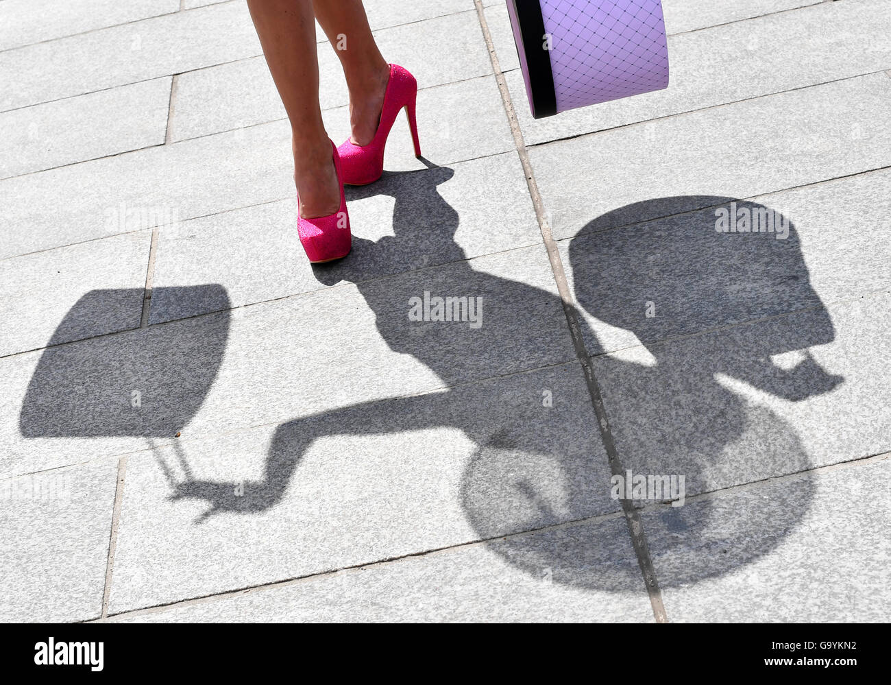 The silhouette of Princess Maja von Hohenzollern, holding hat boxes in her hands, appears on the pavement during a phtoo shoot in Berlin, Germany, 4 July 2016. Photo: Jens Kalaene/dpa Stock Photo
