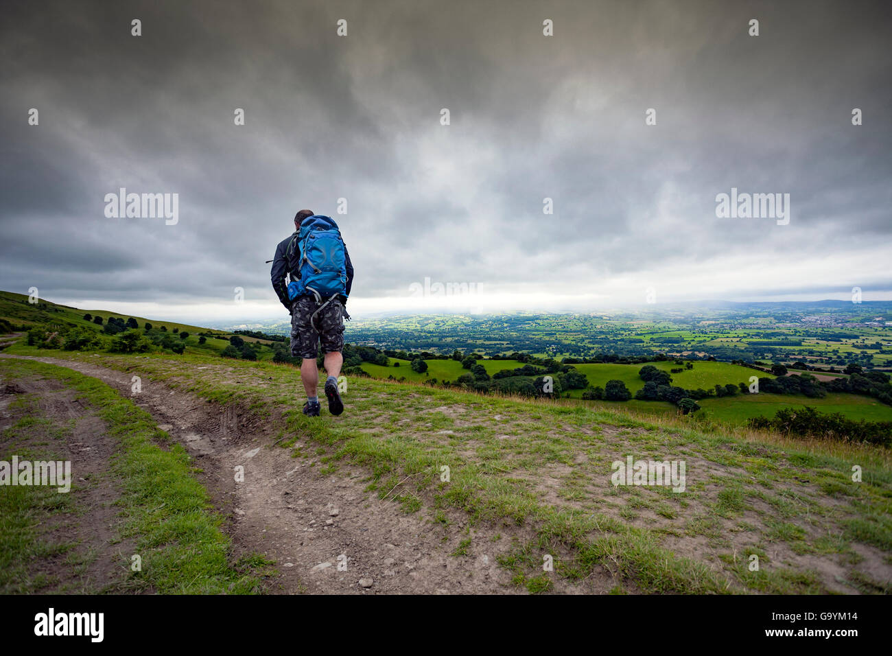 Hill walker walking along a path in the Clwydian Range hills overlooking the beautiful landscape
