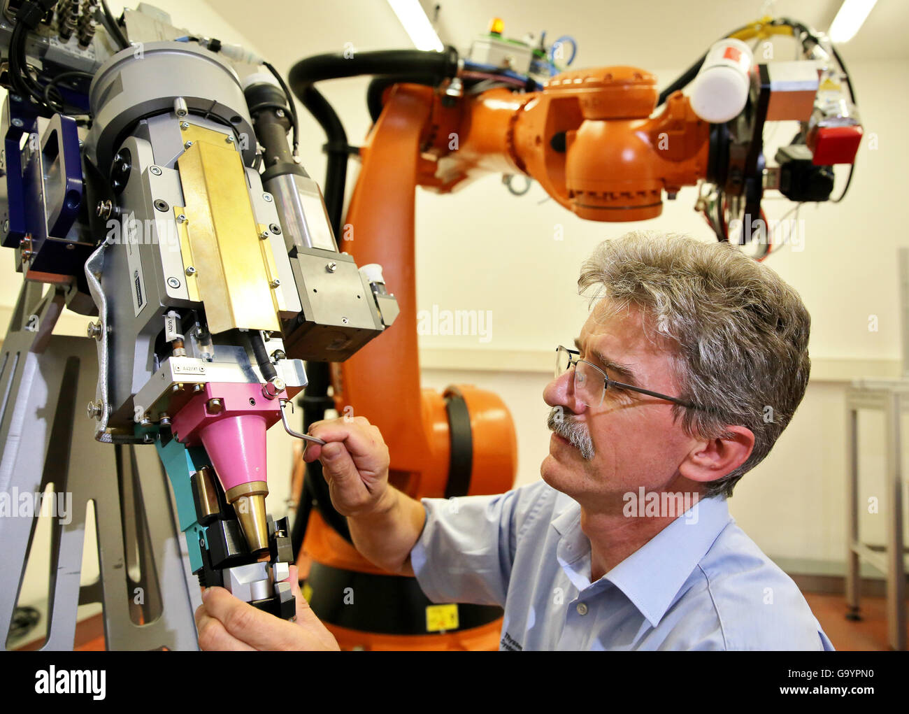 ThyssenKrupp employee Axel Sahl mounts the laser head for an industrial