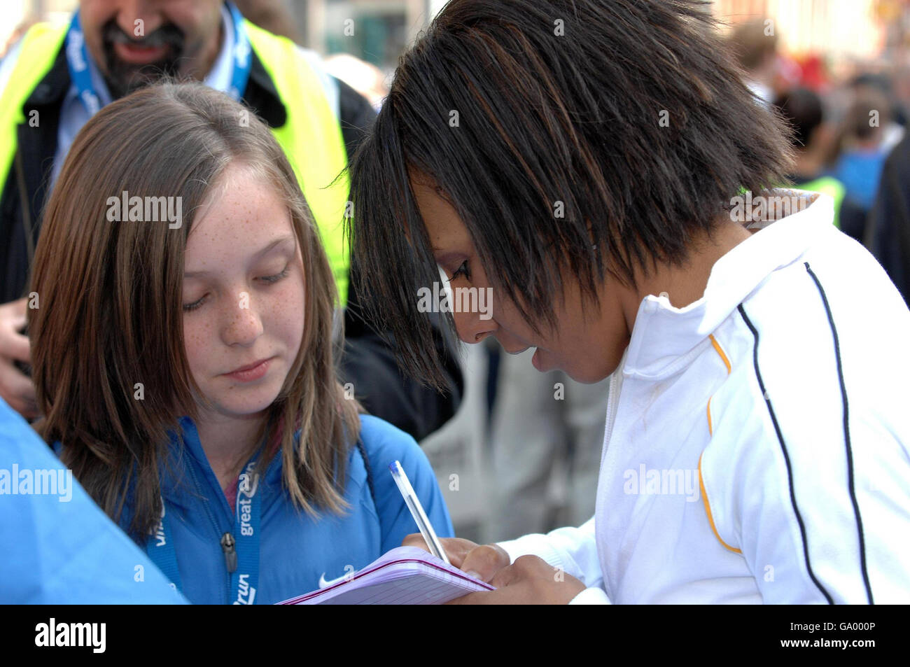 Athletics - BUPA Great Manchester Run. Dame Kelly Holmes signs an autograph for a young fan before the BUPA Great Manchester Run. Stock Photo