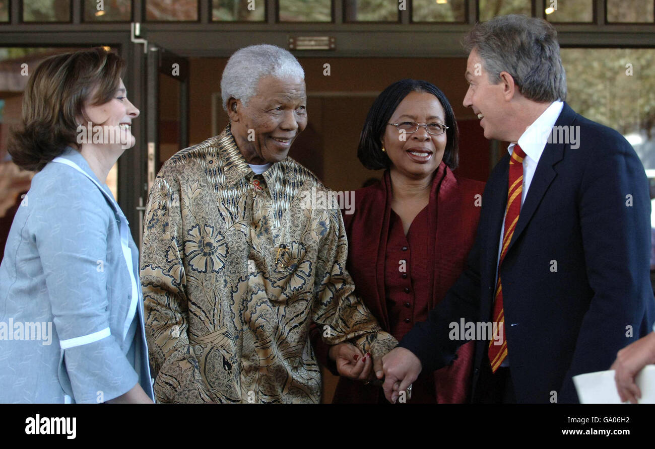 Tony Blair and his wife Cherie are greeted by former South African