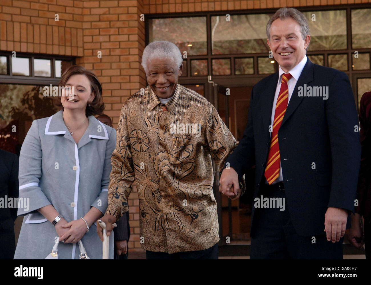 Tony Blair and his wife Cherie are greeted by former South African