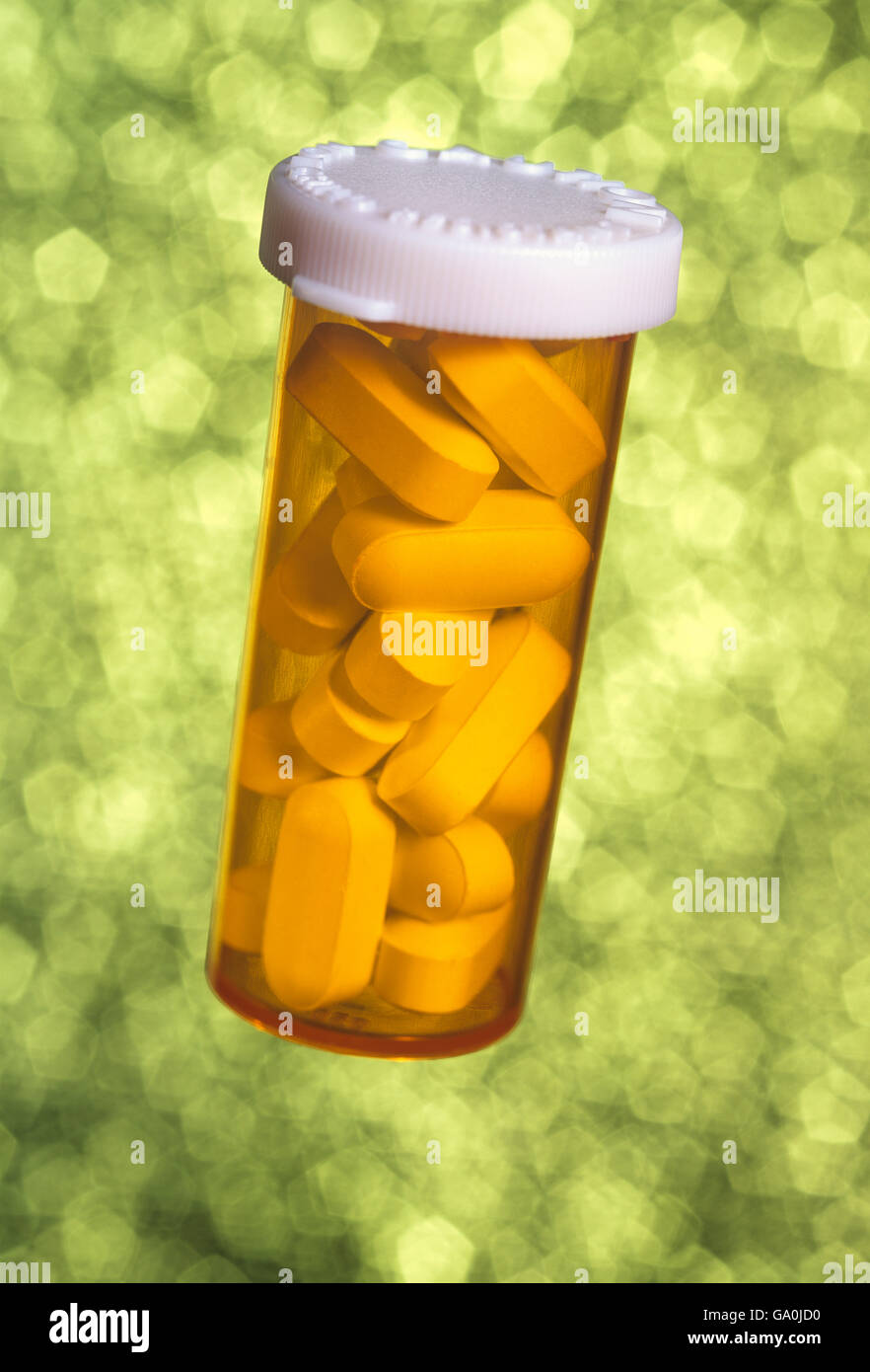 A generic pill bottle with tablets inside against a dreamy soft background Stock Photo