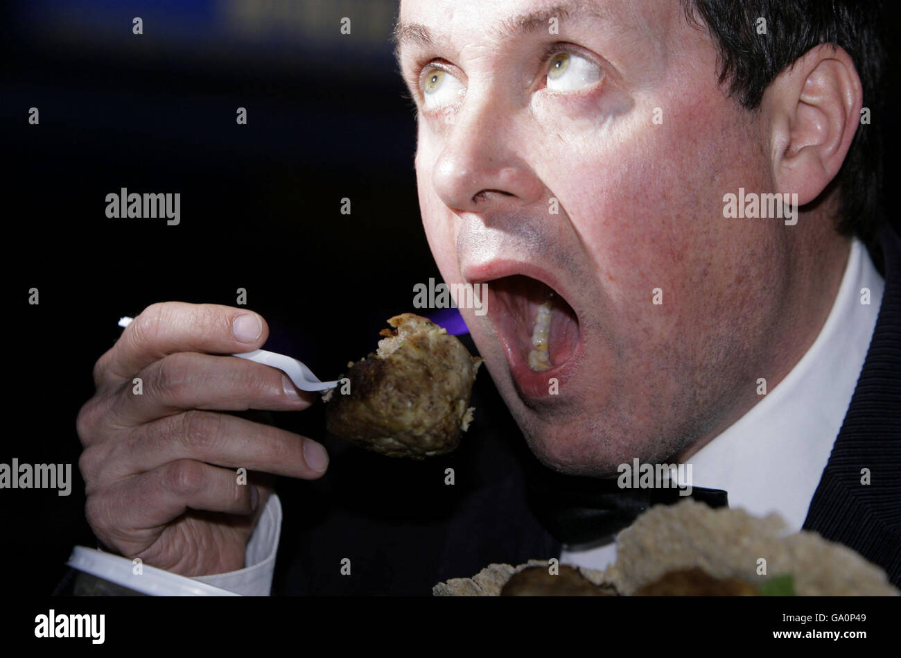 Artist and animal rights activist Mark McGowan eats a piece of Corgi dog in a protest against the Royal family and their treatment of animals, outside Resonance FM radio in Denmark Street, central London. Stock Photo