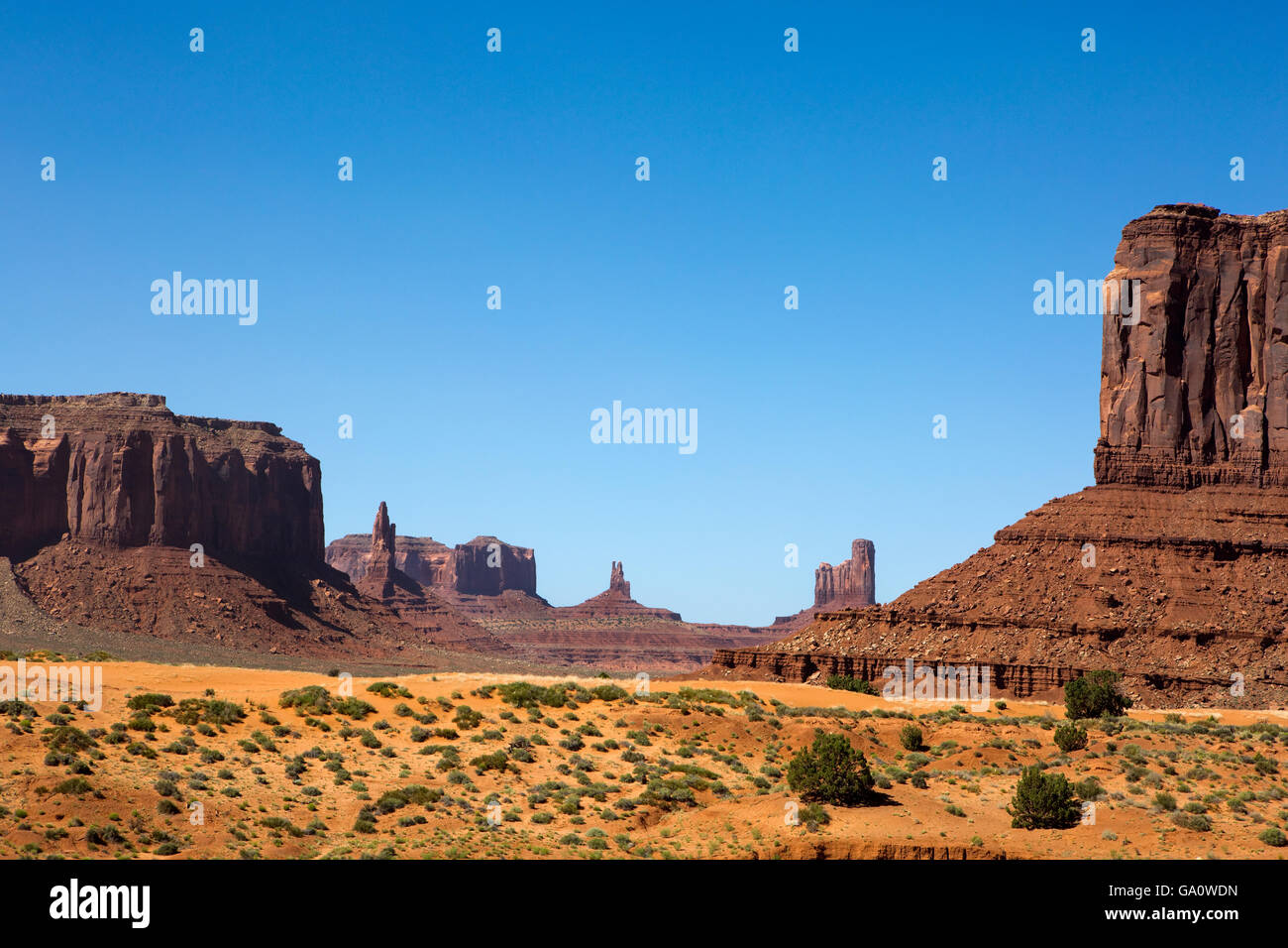 Sandstone mesas rise up out of the desert floor in Monument Valley, Utah, a part of the Navajo Indian Reservation. Stock Photo