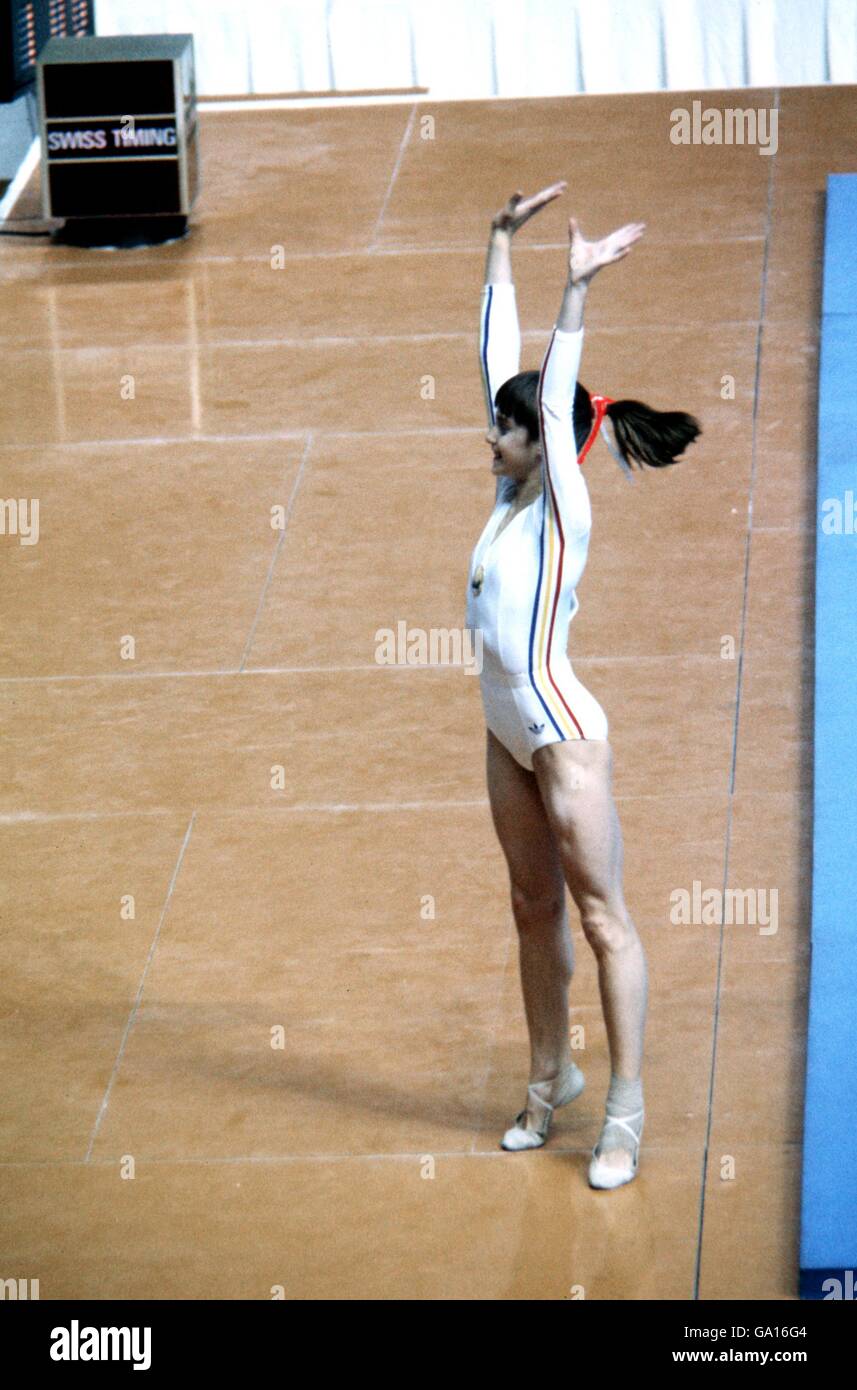 Romania's Nadia Comaneci waves to the crowd in celebration after learning that she had scored a maximum ten points on the uneven bars Stock Photo