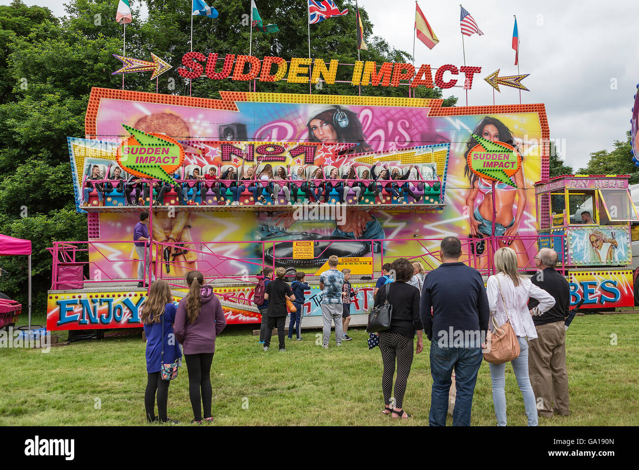 Sudden Impact fairground ride in action with people standing watching Stock Photo