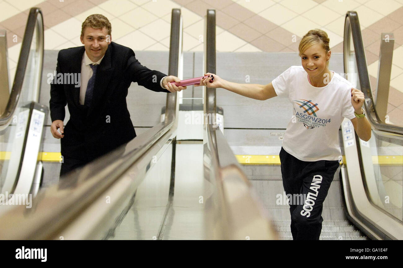 Scottish relay runner Gemma Nicol hands a baton to former Scottish running star Brain Whittle on the escalators in Glasgow's St Enoch Centre, to help promote the city's bid to host the 2014 Commonwealth Games. Stock Photo