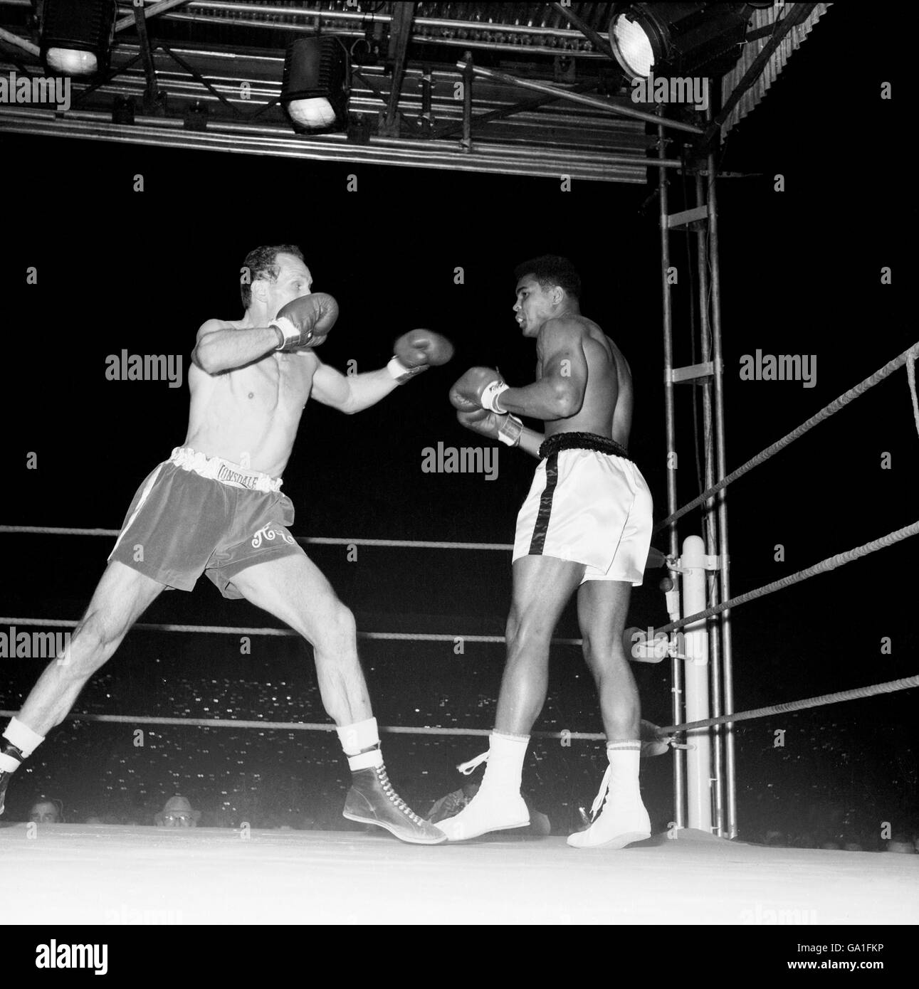 Henry Cooper (l) moves forward after cutting off the ring to leave Muhammad Ali (r) cornered Stock Photo