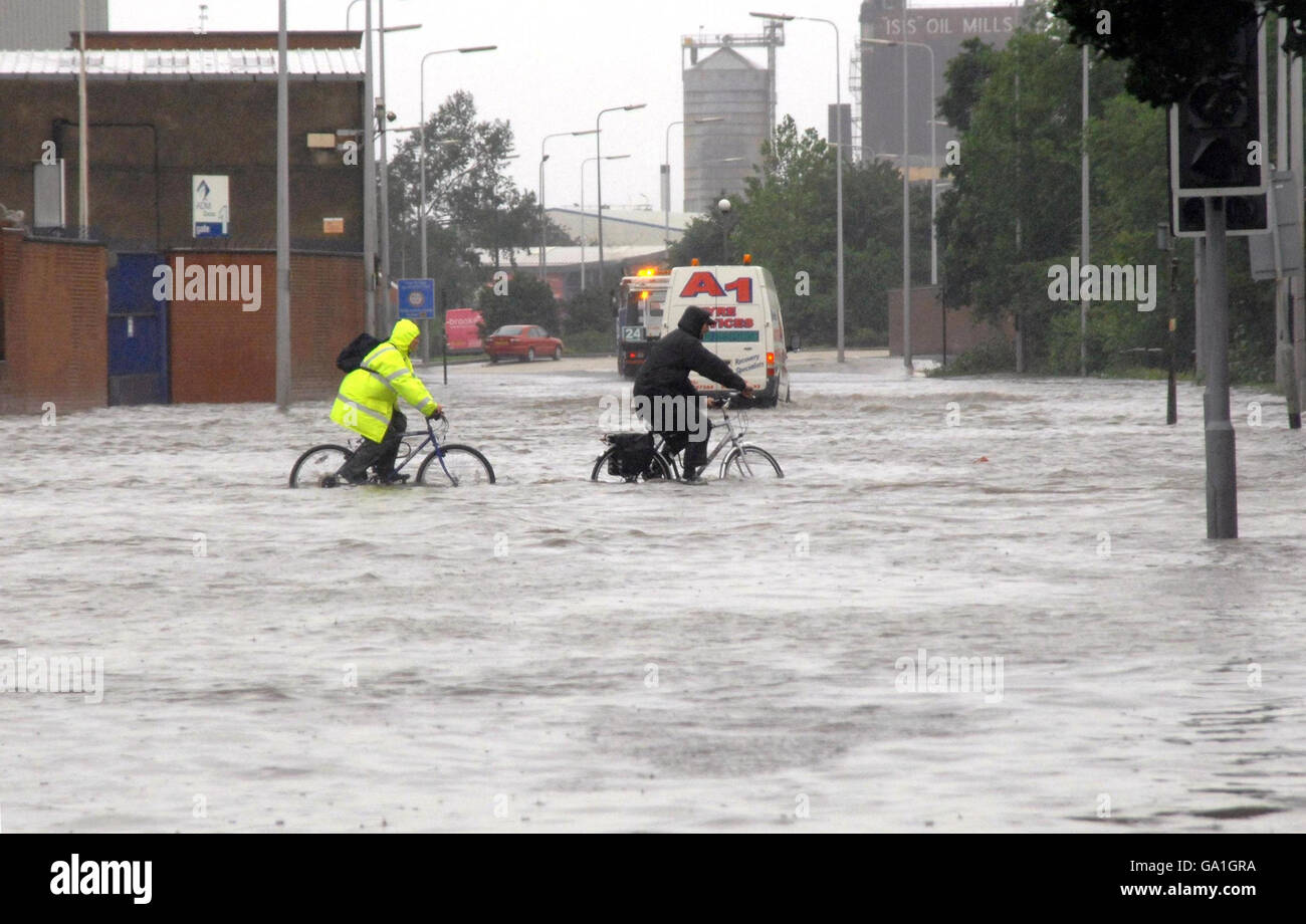 Flood warnings as torrential rain looms. Cyclists cycle through water on Cleveland Street in Hull, after heavy rainfall caused flooding. Stock Photo