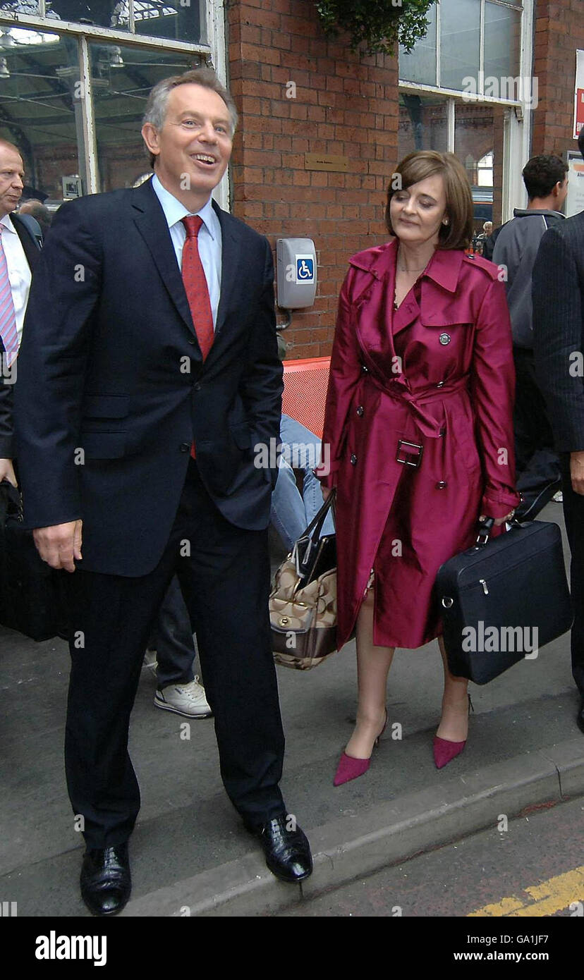 Tony Blair and his wife Cherie wait for transport after arriving at