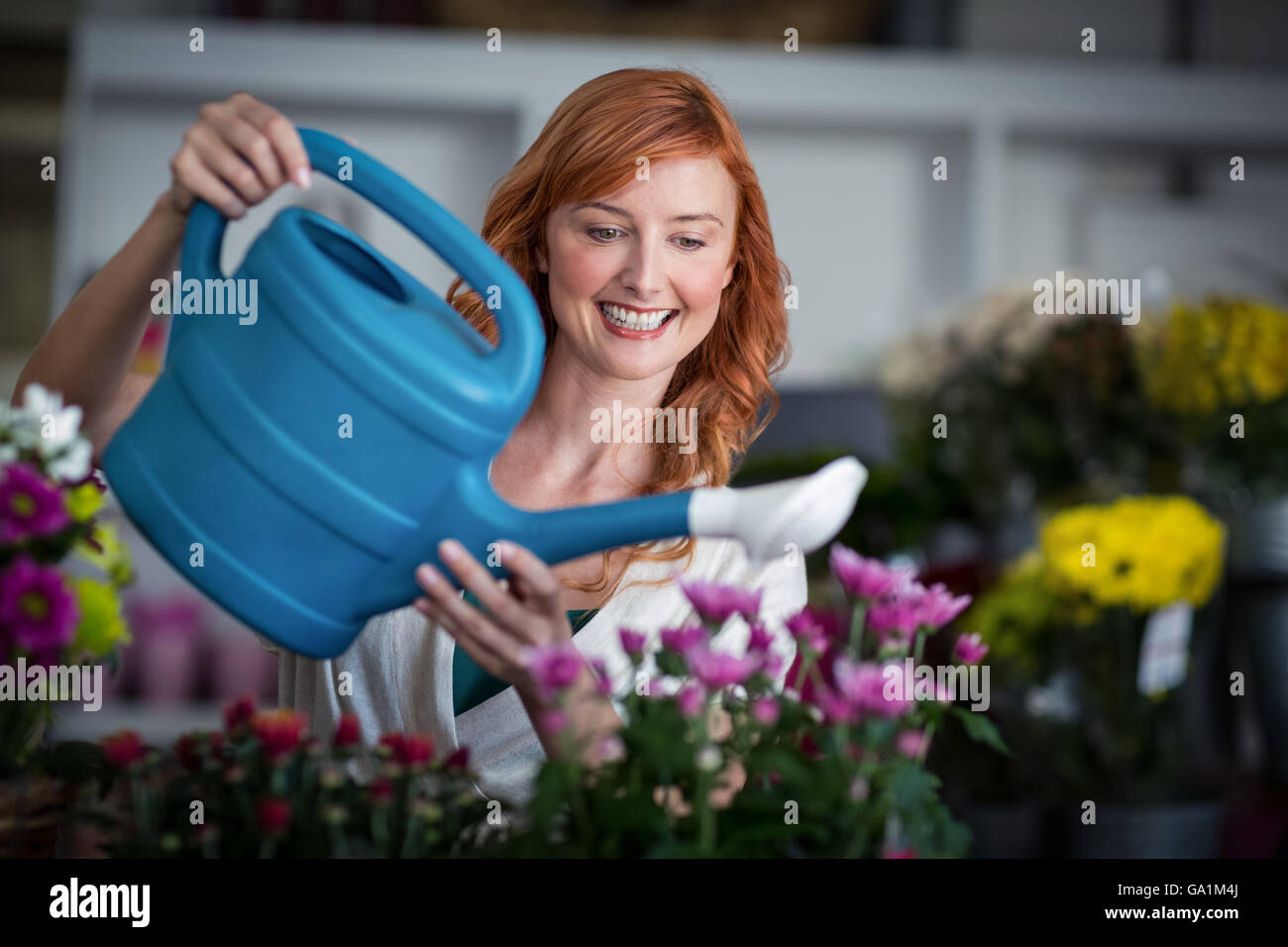 Female florist watering flowers Stock Photo Alamy