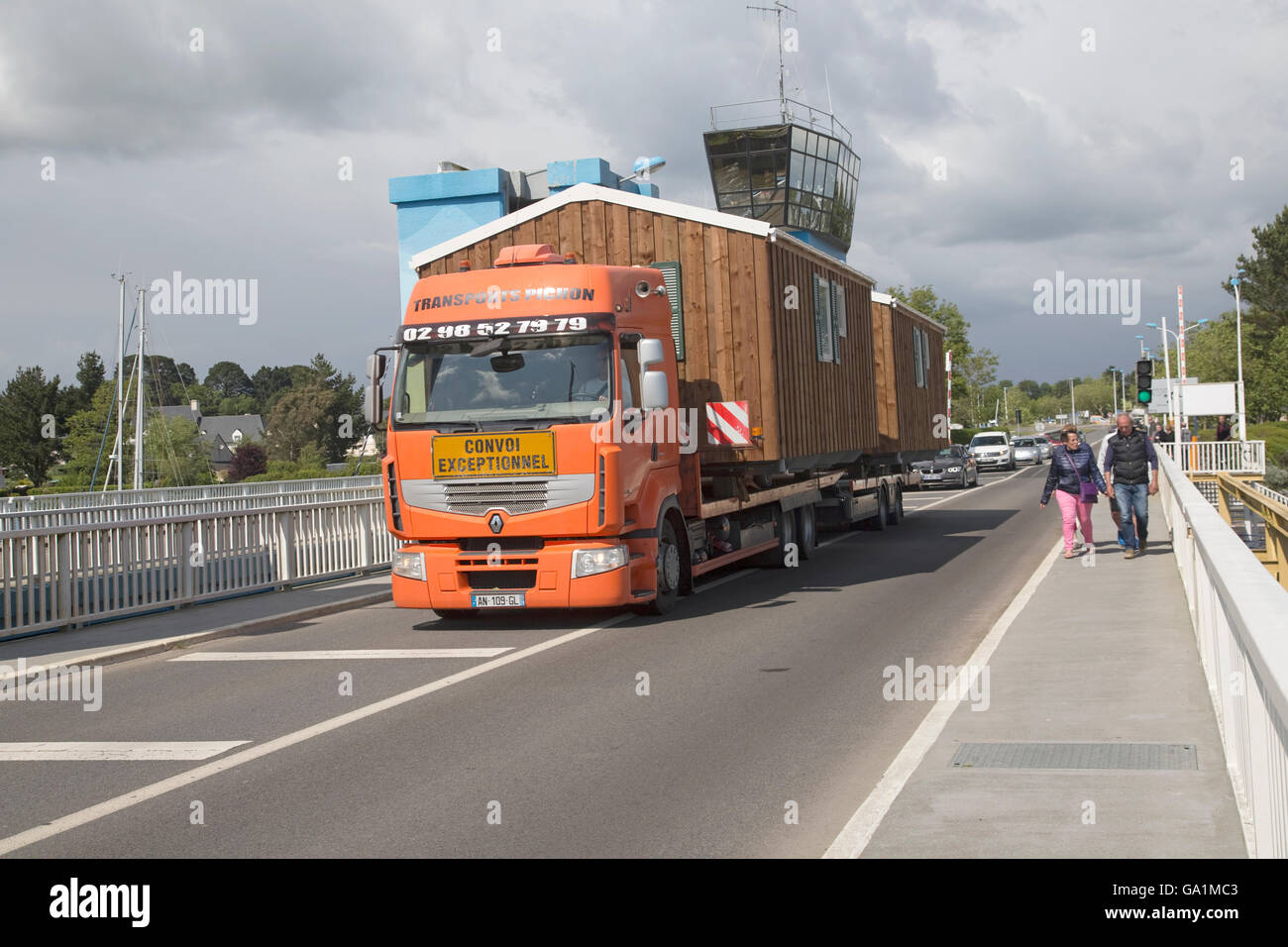 Truck exceptional convoy wide load prefabricated house home crossing La Rance barrage France Stock Photo