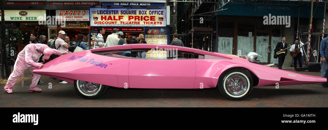 A man dressed as the Pink Panther pushes the 1969 Pink Panther car to Leicester Square in London to take part in the 'West End Live' event. Stock Photo